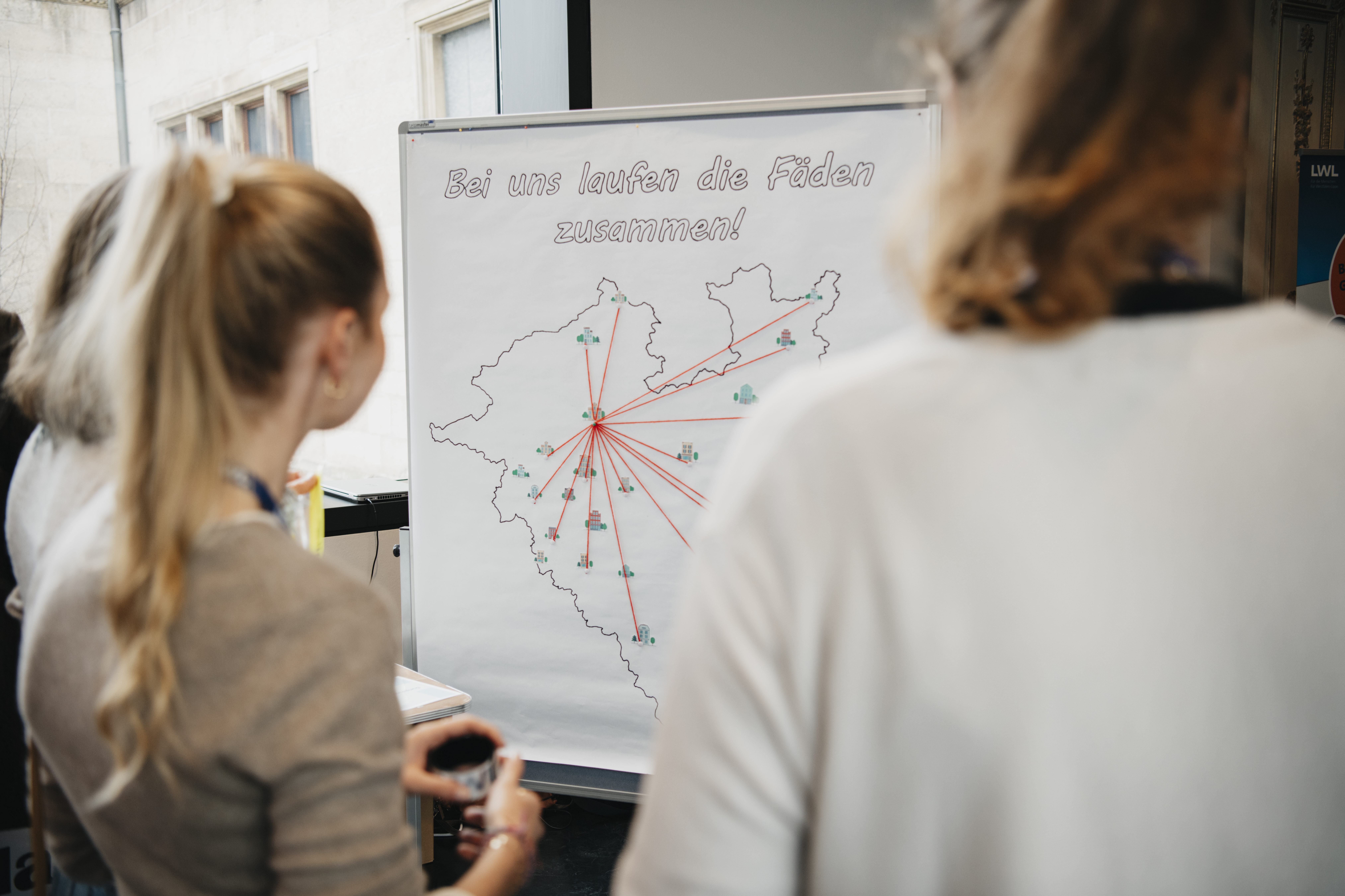 Person schaut auf Visualisierung auf der in einem Kreis Fäden zusammenlaufen